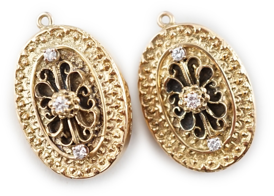 A modern pair of 9ct gold and three stone diamond set oval pendant brooches